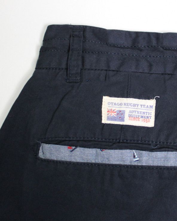 Vignette cousue au dos côté gauche du bermuda Fineberg Otago bleu marine pour homme