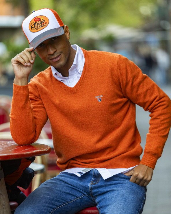 le modèle porte un Pull col V orange Buenos Aires Otago pour homme