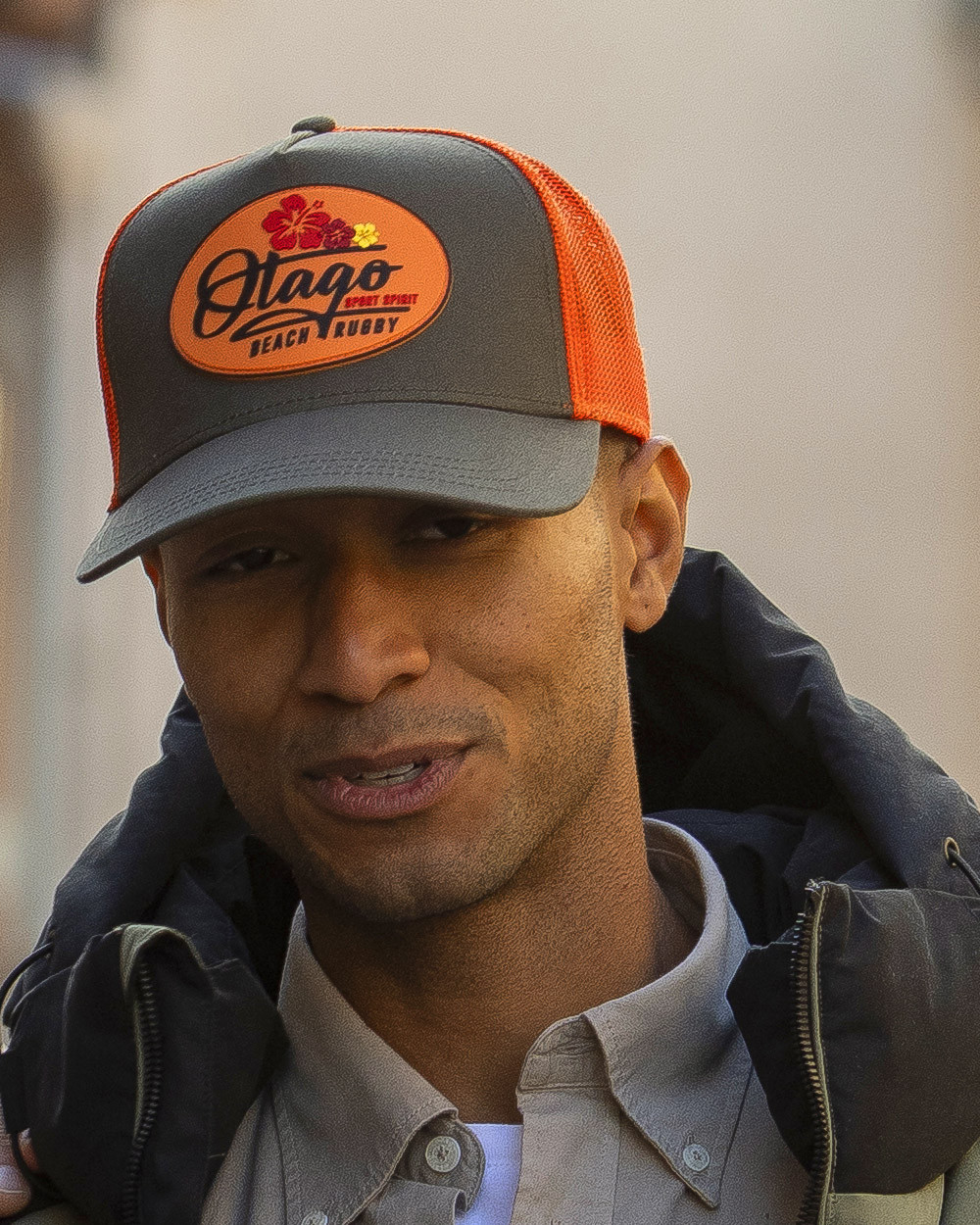 le modèle porte une Casquette Beachcap Otago rugby kaki / orange