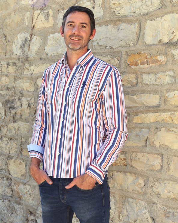 le modèle porte une Chemise manches longues pour homme 298 Otago rayée bleu rouge orange