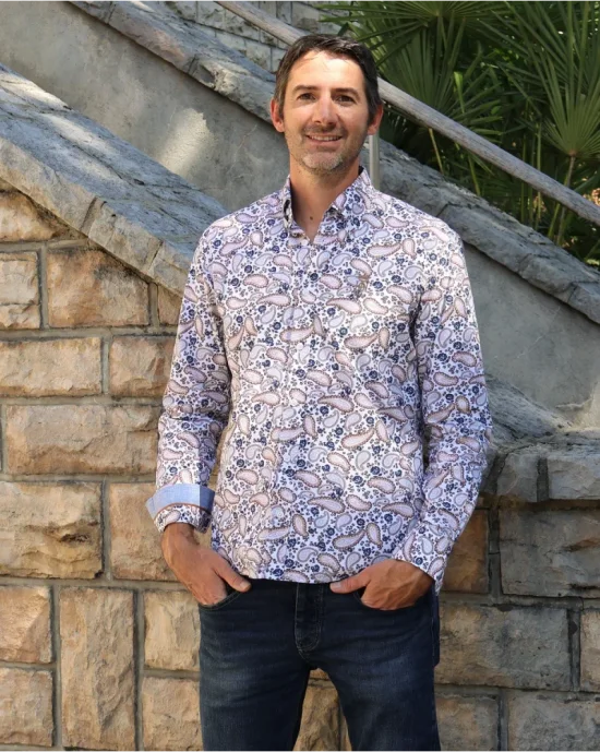le modèle porte une Chemise manches longues pour homme 294 Otago blanche à motifs bleu marine et marron