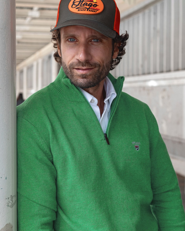 le modèle porte un Pull col zippé vert pomme pour homme Buenos Aires Otago et une casquette Beachcap kaki orange