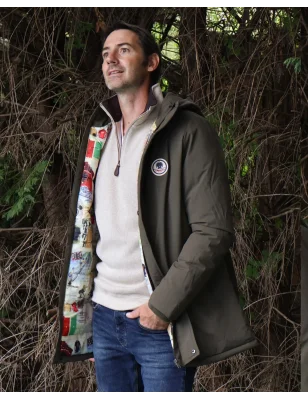 le modèle porte une Doudoune longue kaki déperlante pour homme Lamyan Otago rugby avec capuche avec un sweat col zip écru