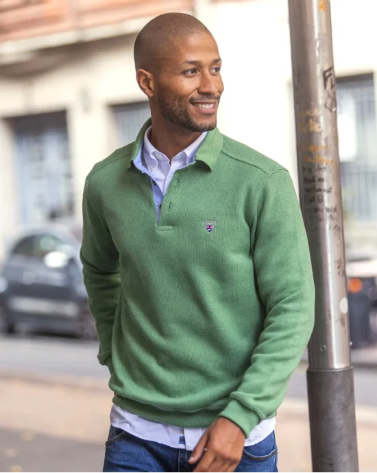 le modèle porte un Polo manches longues pour homme 25POML1 Otago rugby vert ou sweat vert col polo