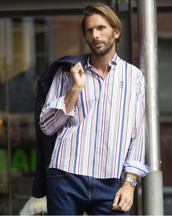 le modèle porte une Chemise manches longues pour homme 298 Otago rayée bleu rouge orange