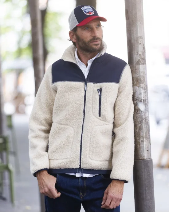le modèle porte une veste polaire écru marine pour homme OTASHERPA stone Otago rugby