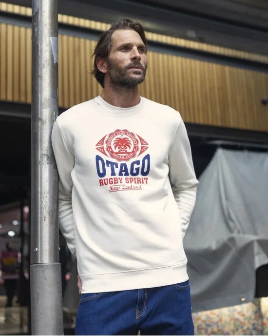 le modèle porte un Sweat col rond EVERLANDY Otago rugby ivoire pour homme