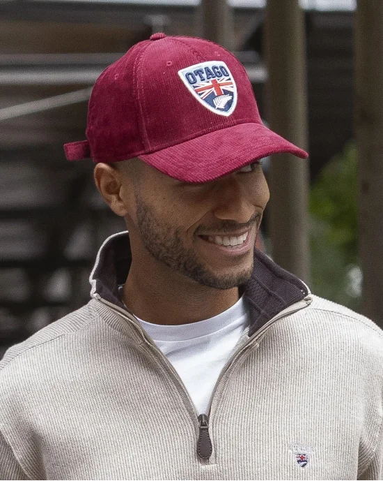 le mannequin porte une Casquette velours bordeaux Cali Otago