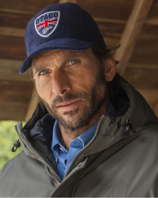 le modèle porte une Casquette velours bleu marine Cali Otago