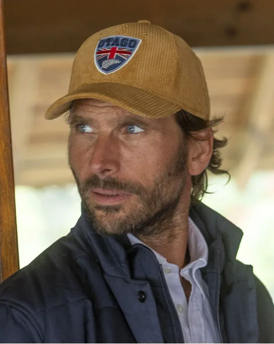 le modèle porte une Casquette velours camel Cali Otago