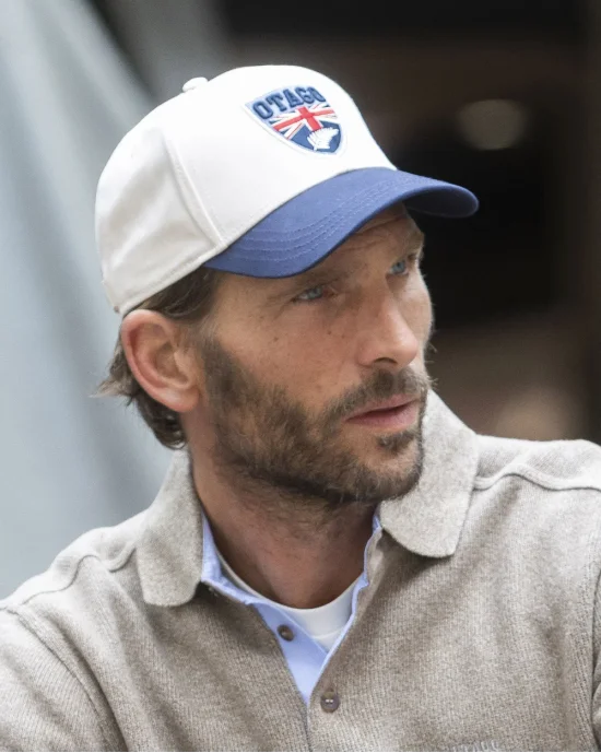 le modèle porte une Casquette Cali écru et bleu marine Otago