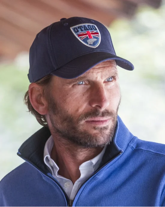le modèle porte une Casquette Cali bleu marine Otago