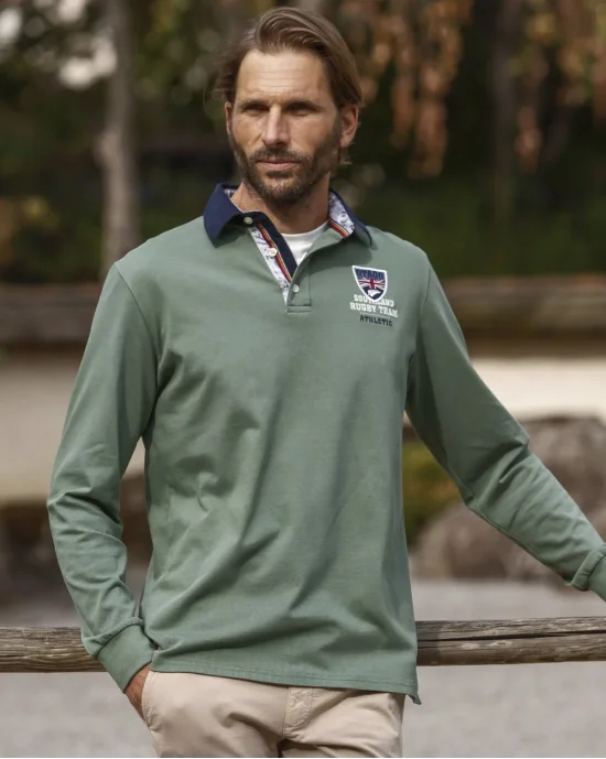 le modèle porte un Polo manches longues kaki pour homme PAGUETAG Otago rugby