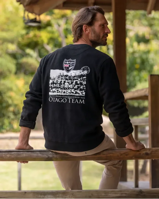 le modèle porte un Sweat col rond noir pour homme TEAM Otago rugby sérigraphié de dos