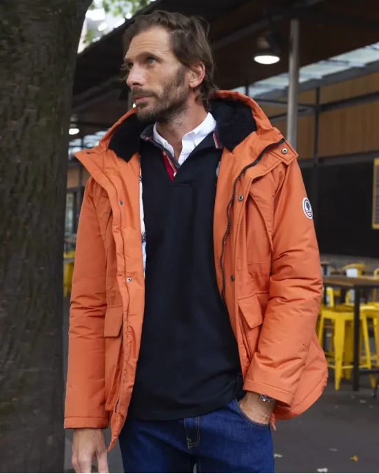 le modèle porte une Parka orange pour homme Padded Otago rugby avec capuche